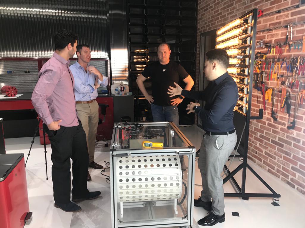 Discussion around the motor-generator — Andrii explaining system operation with illuminated light wall